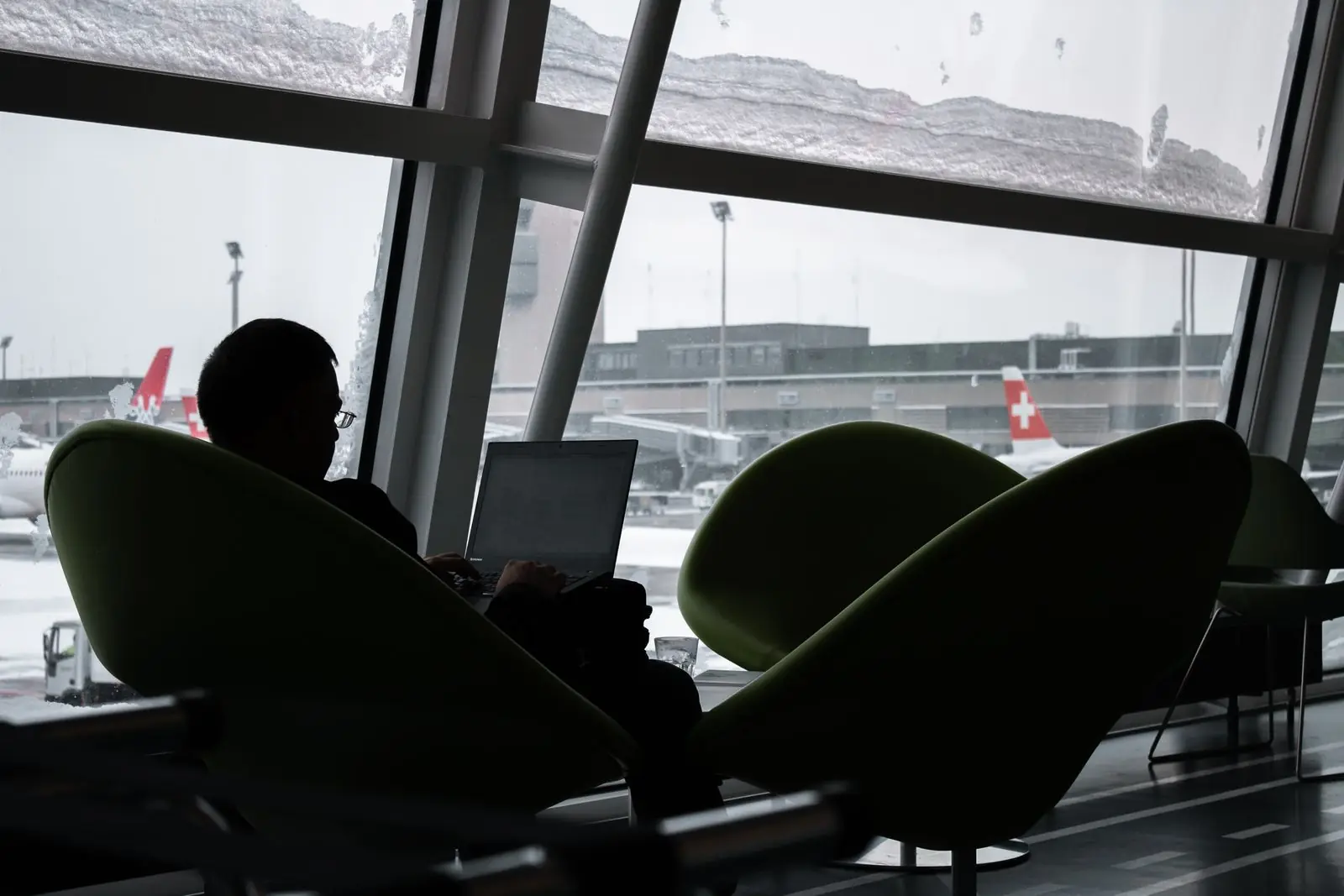 A business traveller working on a laptop in an airport lounge