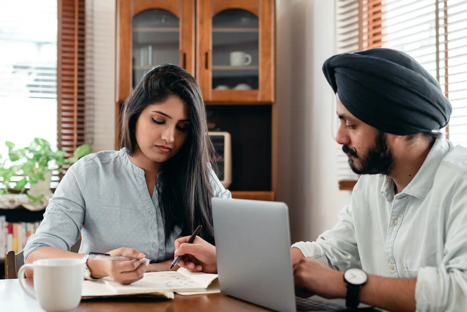 Two people reviewing work together at a laptop